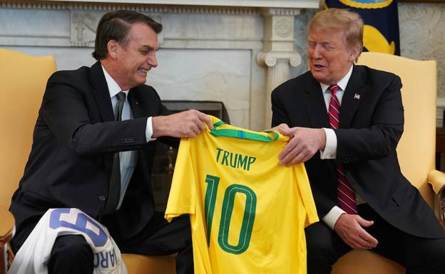Bolsonaro regala a Trump una camiseta de la selección brasileña de fútbol con su nombre, durante su reunión de este martes en la Casa Blanca.