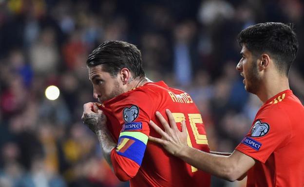 Sergio Ramos, besándose el escudo de la selección española tras anotar el gol de la victoria.