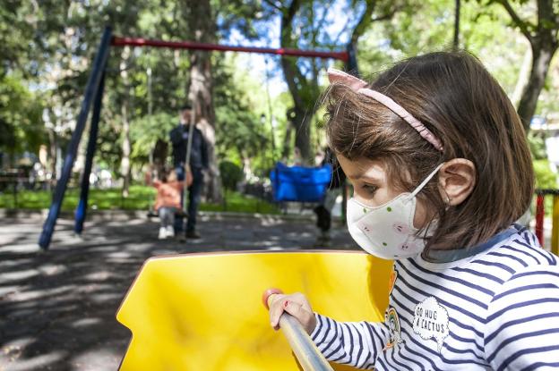 Una niña alérgica juega en el parque del paseo de Cánovas con mascarilla para evitar el efecto de los pólenes. :: JORGE REY