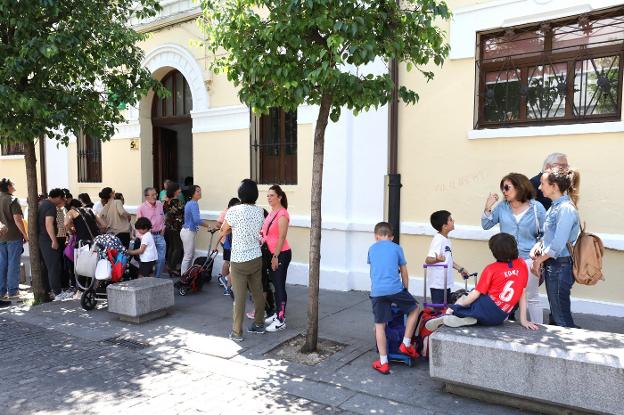 Padres esperando a sus hijos en la puerta del Trajano. :: brígido