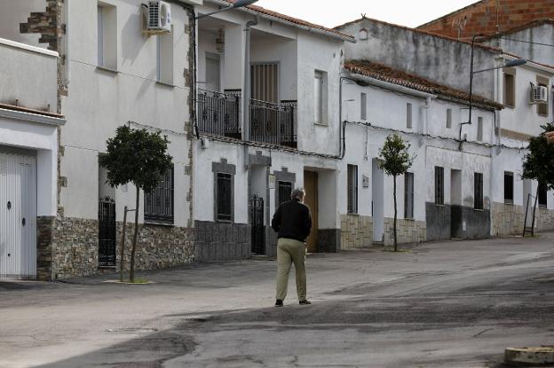 Una persona cruza la calle en una localidad de la provincia de Cáceres. :: hoy