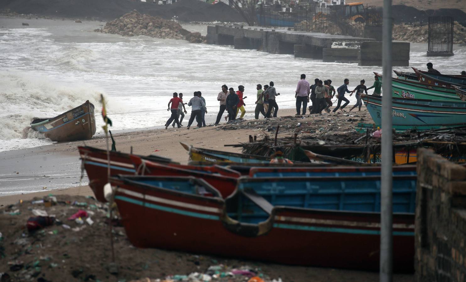 Los pescadores se preparan sacando los botes del mar arábigo ante la pronta llegada del ciclón Vayu a Veraval (india)