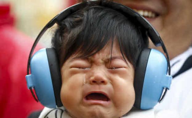 Un bebé de siete meses llora en los brazos de su padre, en Japón