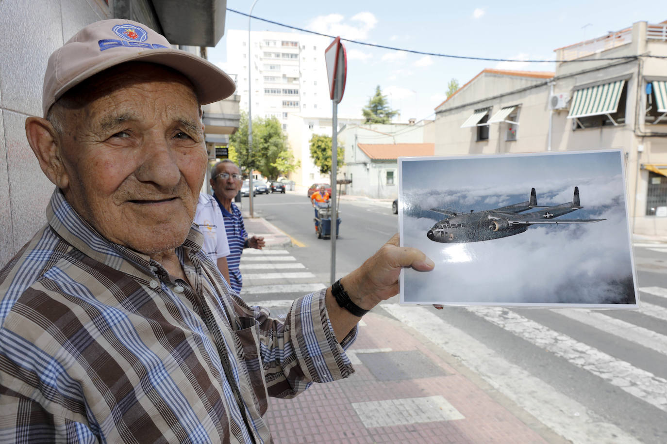 Francisco Corrales en la puerta del bar 'La Bodega', enseñando una imagen de un avión similar al que se estrelló en Cáceres.