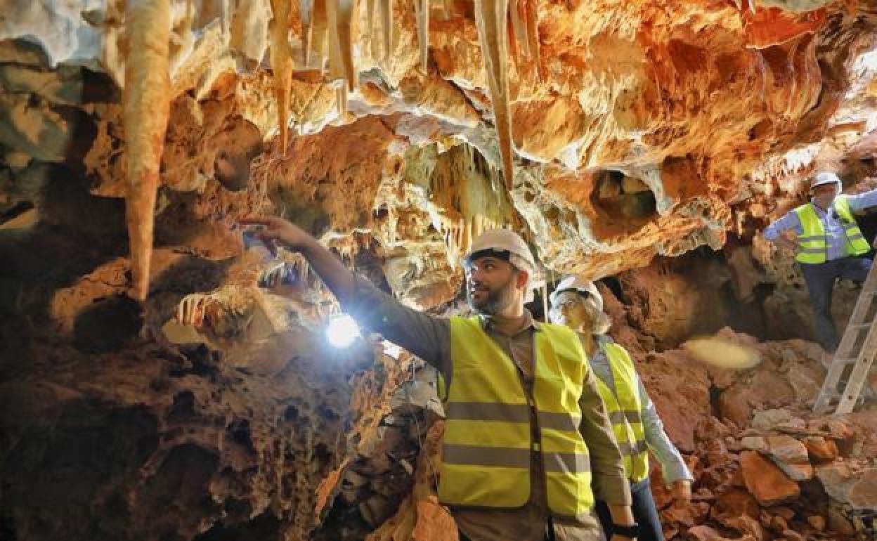 El alcalde, Luis Salaya, muestra a la consejera de Movilidad, Leire Iglesias, una de las estalactitas de la cueva del Carrucho. / L. CORDERO