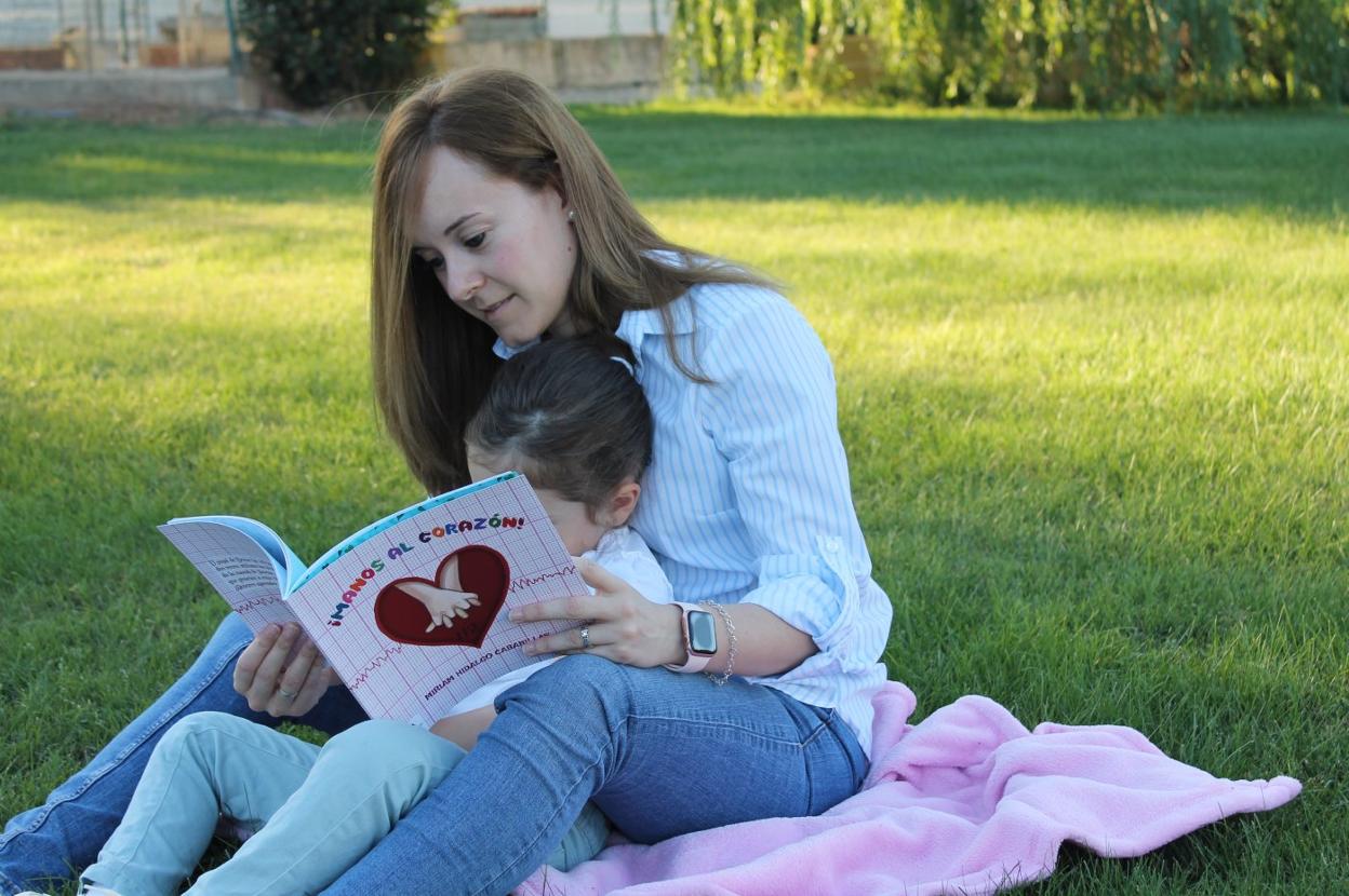 Miriam Hidalgo lee con su hija de 4 años el cuento que ha escrito sobre primeros auxilios. :: HOY