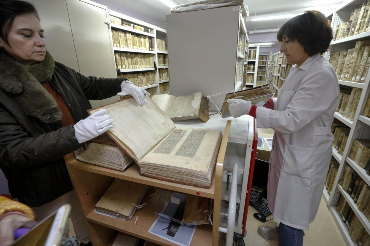 La directora y una técnico de la biblioteca pública junto a uno de los libros recientemente restaurados en el IPCE. :: lorenzo cordero