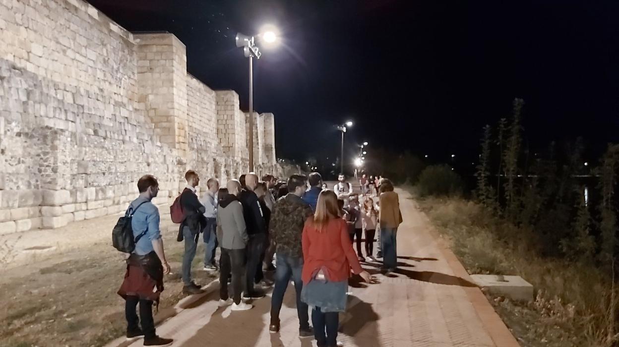 Un grupo, sigue las explicaciones de Israel al pie de la muralla de la Alcazaba, en el paseo de la Isla. :: hoy