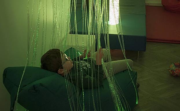 Sala multisensorial. A través de la luz, el movimiento o el tacto estimulan los sentidos o los calman para captar la atención y predisponerlos a recibir otras terapias. En la foto, MIguel en la cascada de cables fluorescentes.: PAKOPÍ
