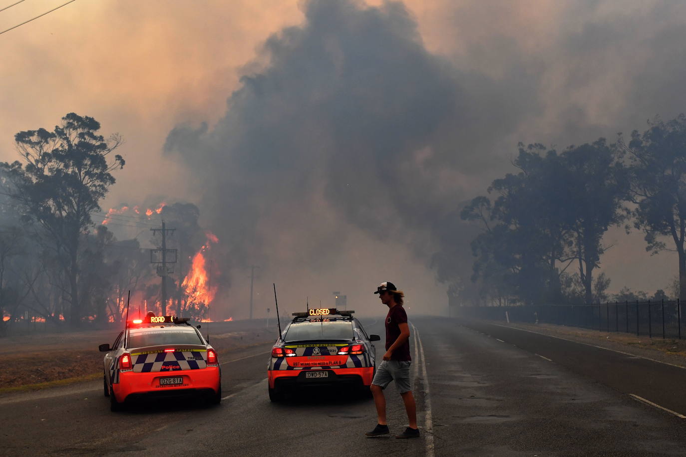 La patrulla de carreteras vigila las llamas en Tahmoor, a 100 kilómetros de Sidney