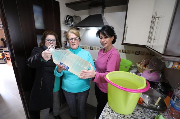 María Blanco, en el centro, junto a otras dos vecinas afectadas, sin agua en casa. :: BRÍGIDO