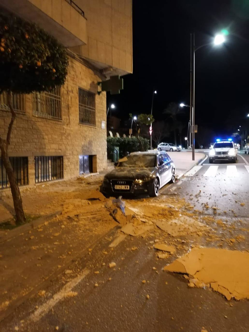 Trozos de la fachada que han caído sobre la avenida La Salle en Plasencia y que permanece cortada al tráfico.