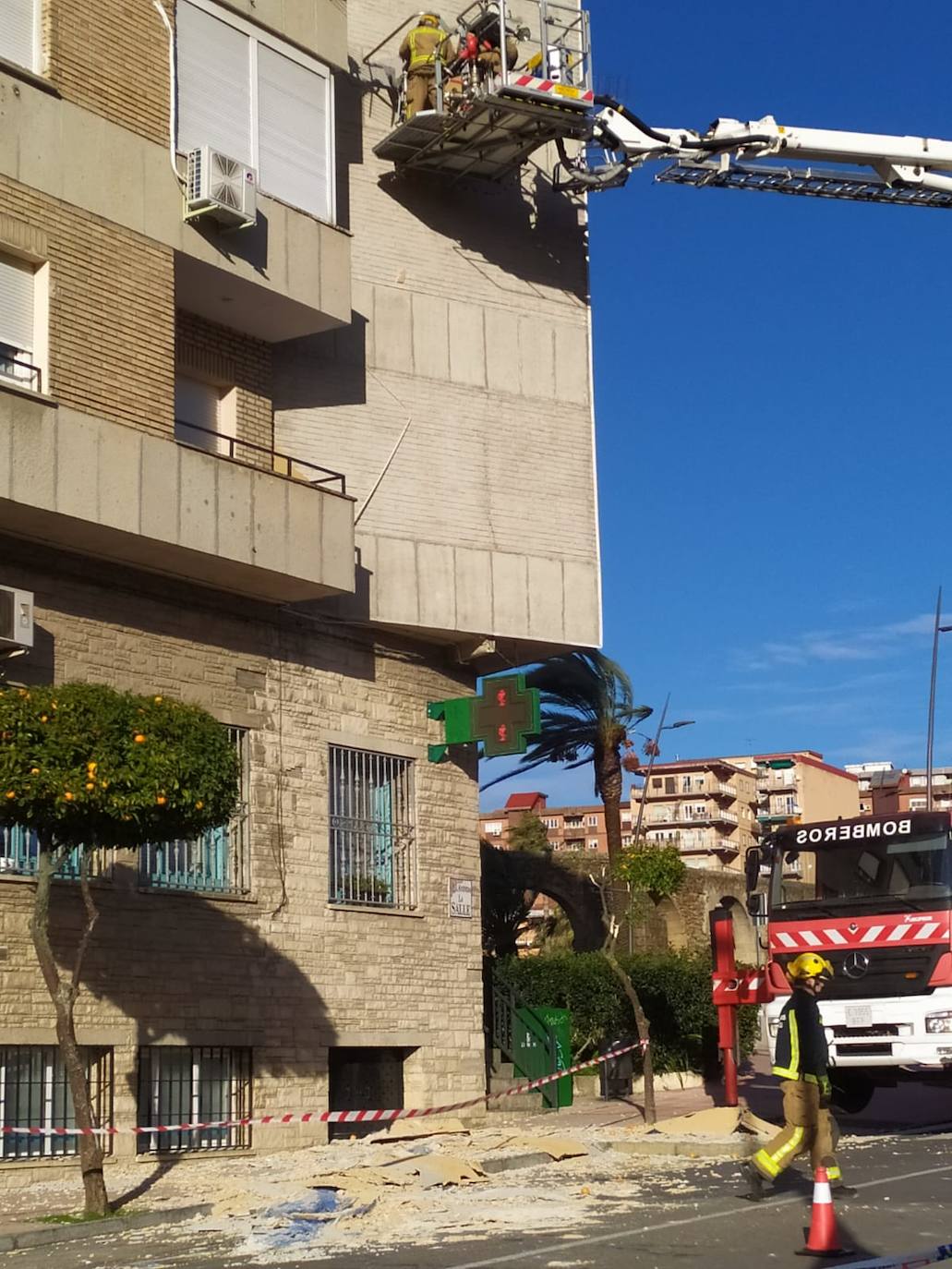 Bomberos trabajando en la fachada del edificio afectado por los desprendimientos de la avenida La Salle de Plasencia. 