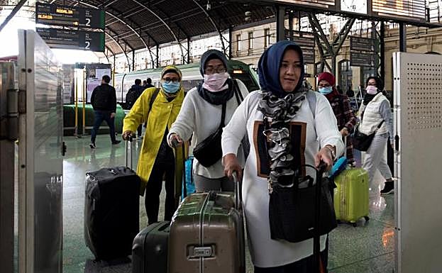Un grupo de turistas asiáticos llegan protegidos con mascarillas.