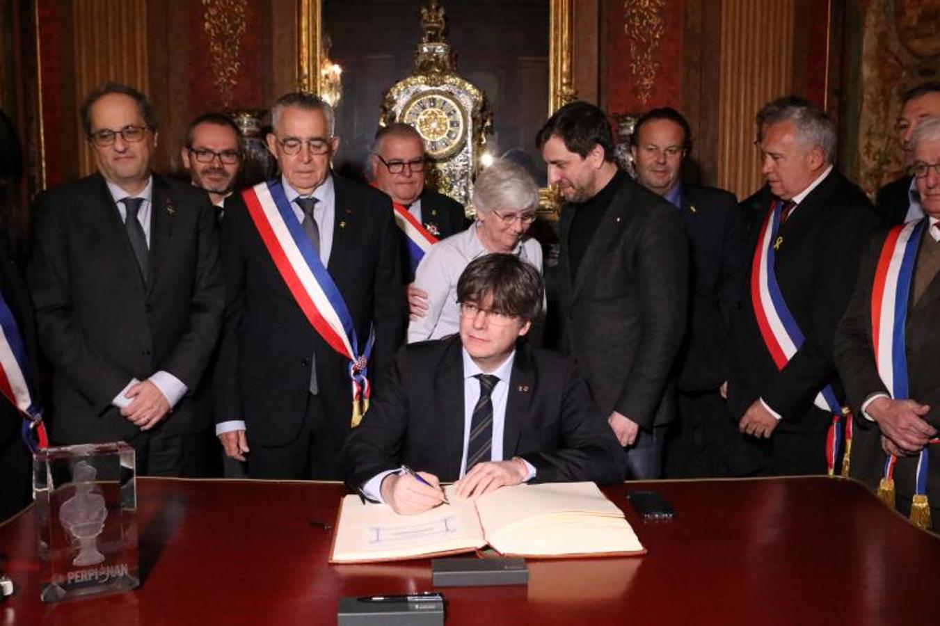 Carles Puigdemont firma un libro en el ayuntamiento de Perpiñán.