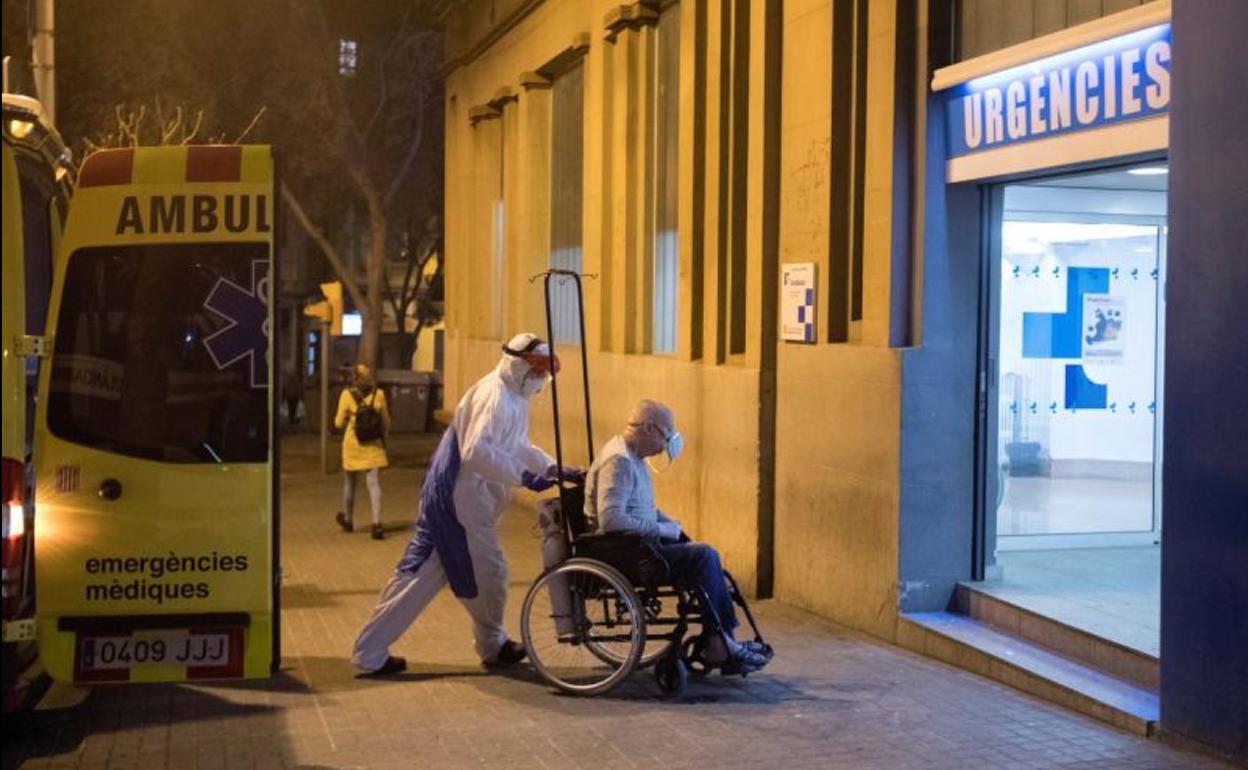 Un sanitario transporta a una persona a las urgencias del Hospital Dos de Maig en Barcelona.