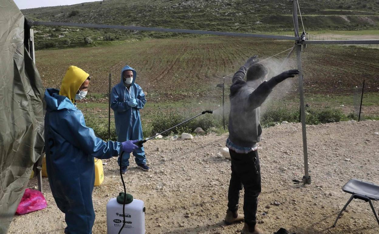 Desinfección de un trabajador palestino en Hebrón antes de regresar a Israel.