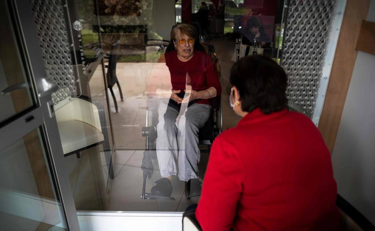 Una mujer habla con su madre, separadas por un cristal, en una residencia de ancianos de Toulouse (Francia).