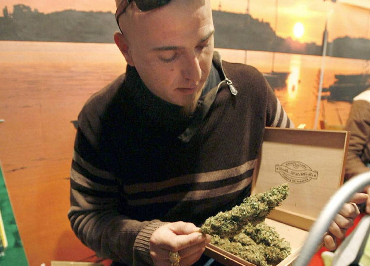 Un vendedor de cannabis muestra su producto en una feria.