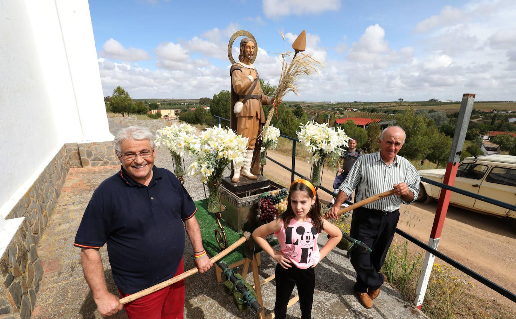 Pedro, su nieta María y Valeriano, en Villafranca junto a una imagen del santo. 