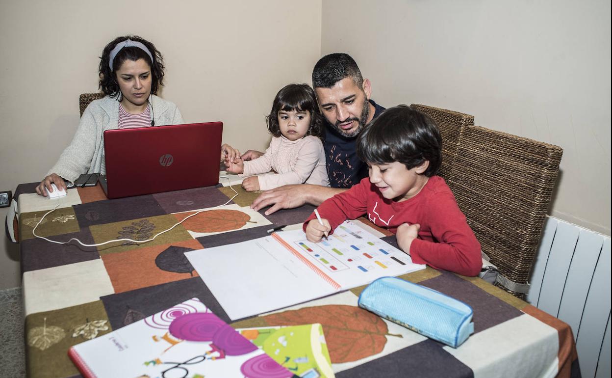 Diego ayuda con las tareas a sus hijos mientras su mujer trabaja. 