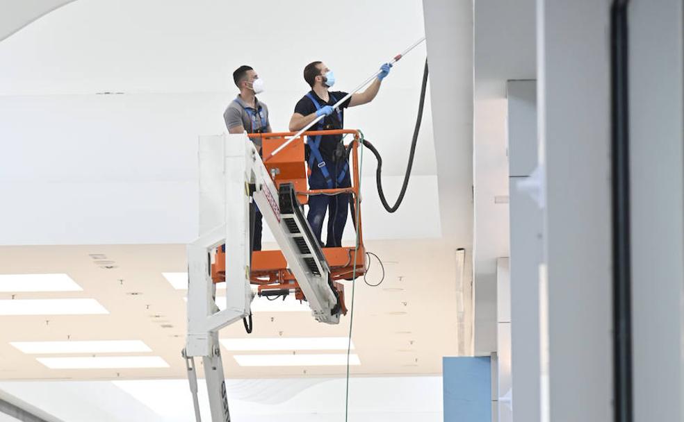 Dos trabajadores desinfectando la galería comercial de El Faro para su reapertura. 