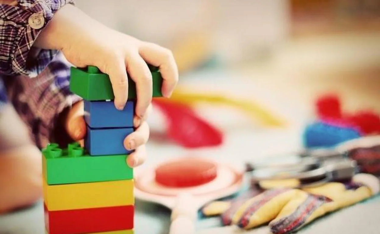 Un niño juega con piezas de construcción.