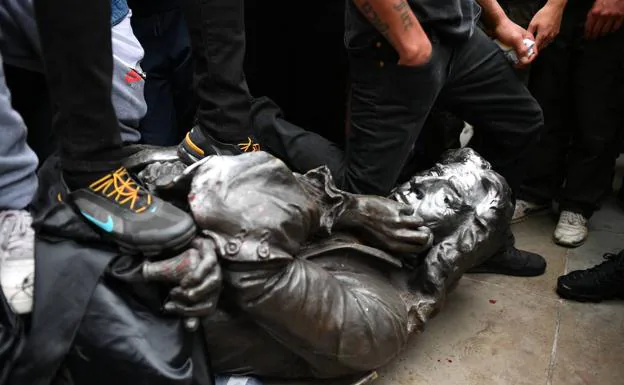 Un manifestante pone la rodilla en el cuello de la estatua del esclavista inglés Edward Colston, derribada en la ciudad de Bristol.