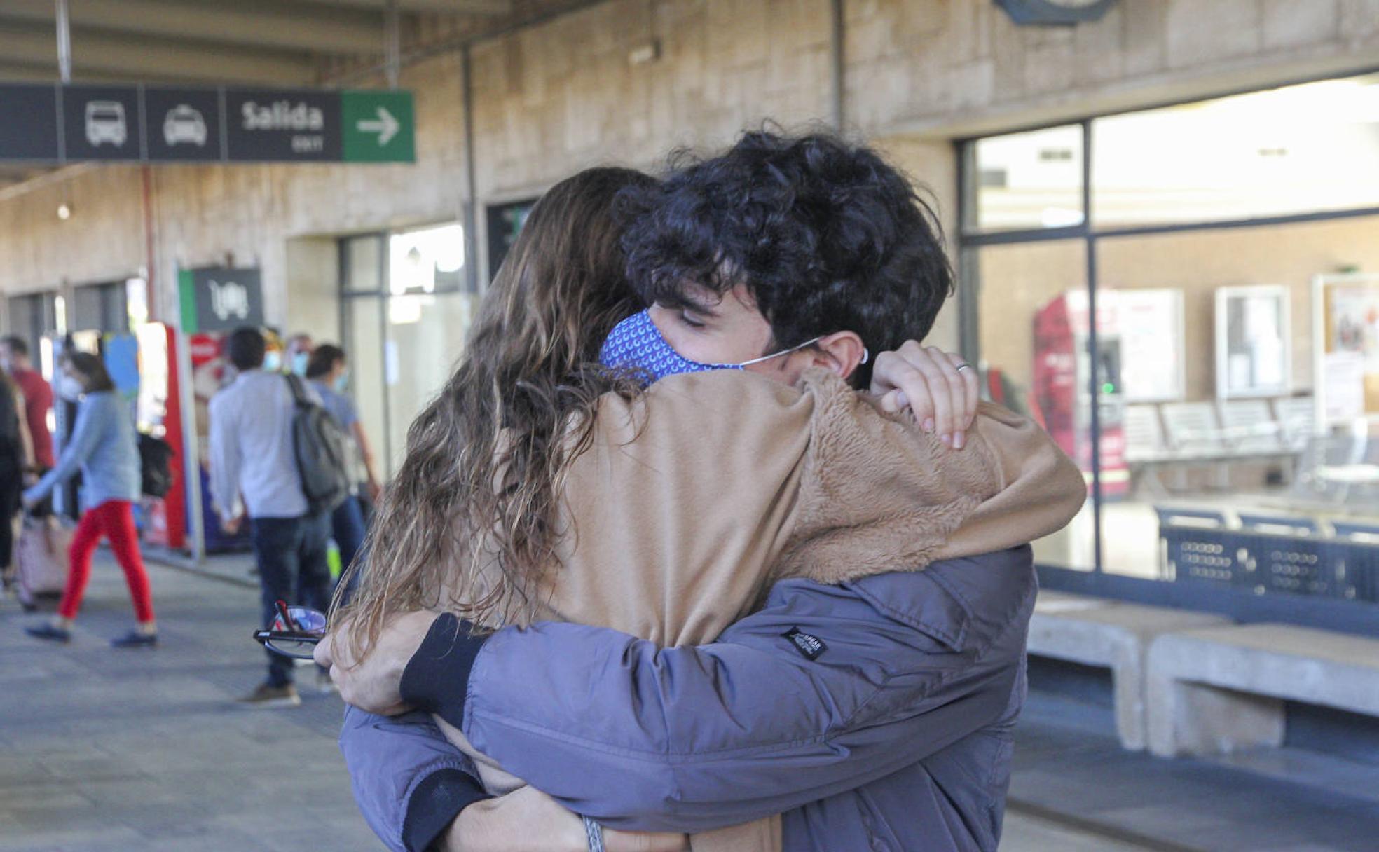 Fernando y Clara abrazándose, con mascarilla, después de tres meses sin verse.