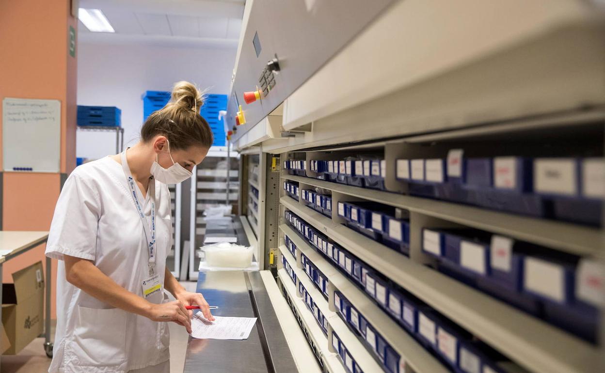 Una farmacéutica busca un medicamento en la farmacia de un hospital.