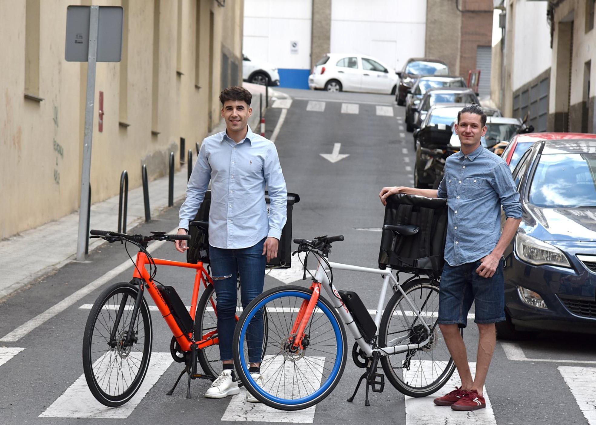 Nacho del Río y Miguel Ángel Sánchez, con dos de las bicicletas eléctricas que usan para el reparto. 