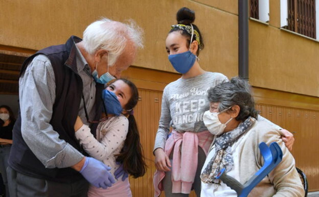Abuelos y nietas se abrazan en Milán (Italia)
