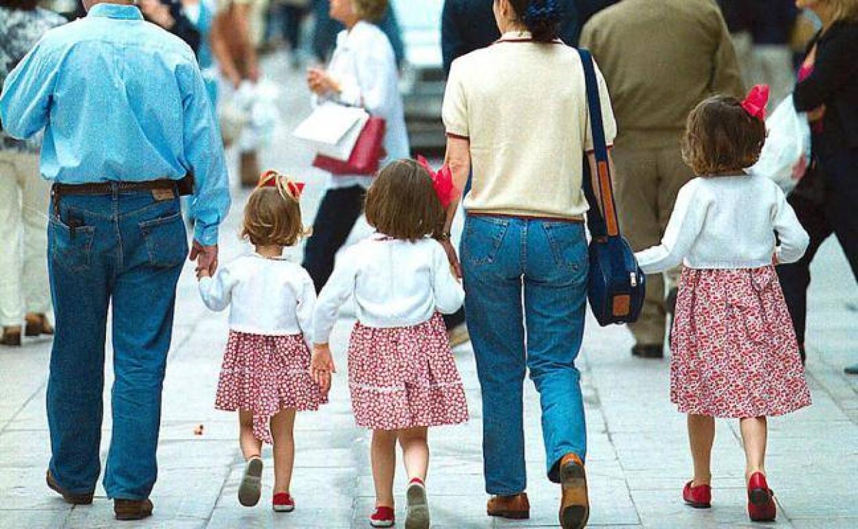 Una familia pasea por la calle. 