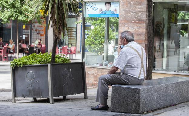 Francisco Méndez, un vecino cacereño, fumando ayer en un banco, apartado de la gente. 