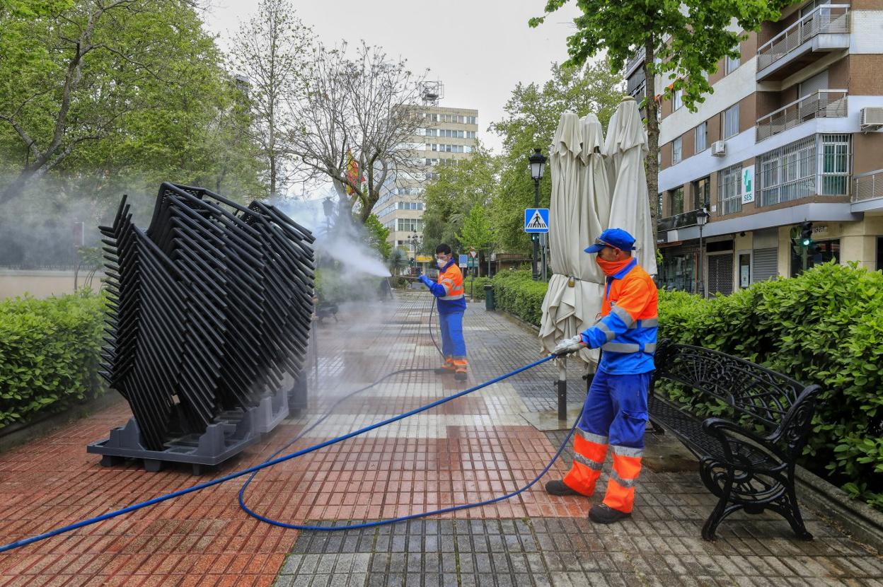 Operarios de Conyser desinfectando las sillas apiladas de una terraza el pasado mes de abril. 