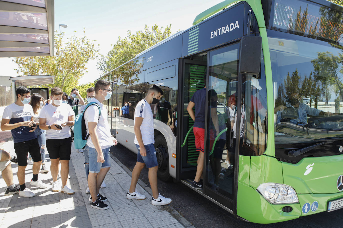 En el campus de Cáceres. Universitarios cogiendo el autobús de manera ordenada y con mascarilla. 