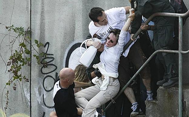 Varias personas tratan de evacuar a una mujer.