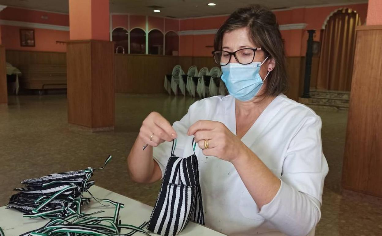 María del Carmen confecciona una de las 2.500 alforjas repartidas con motivo de la Castañá 