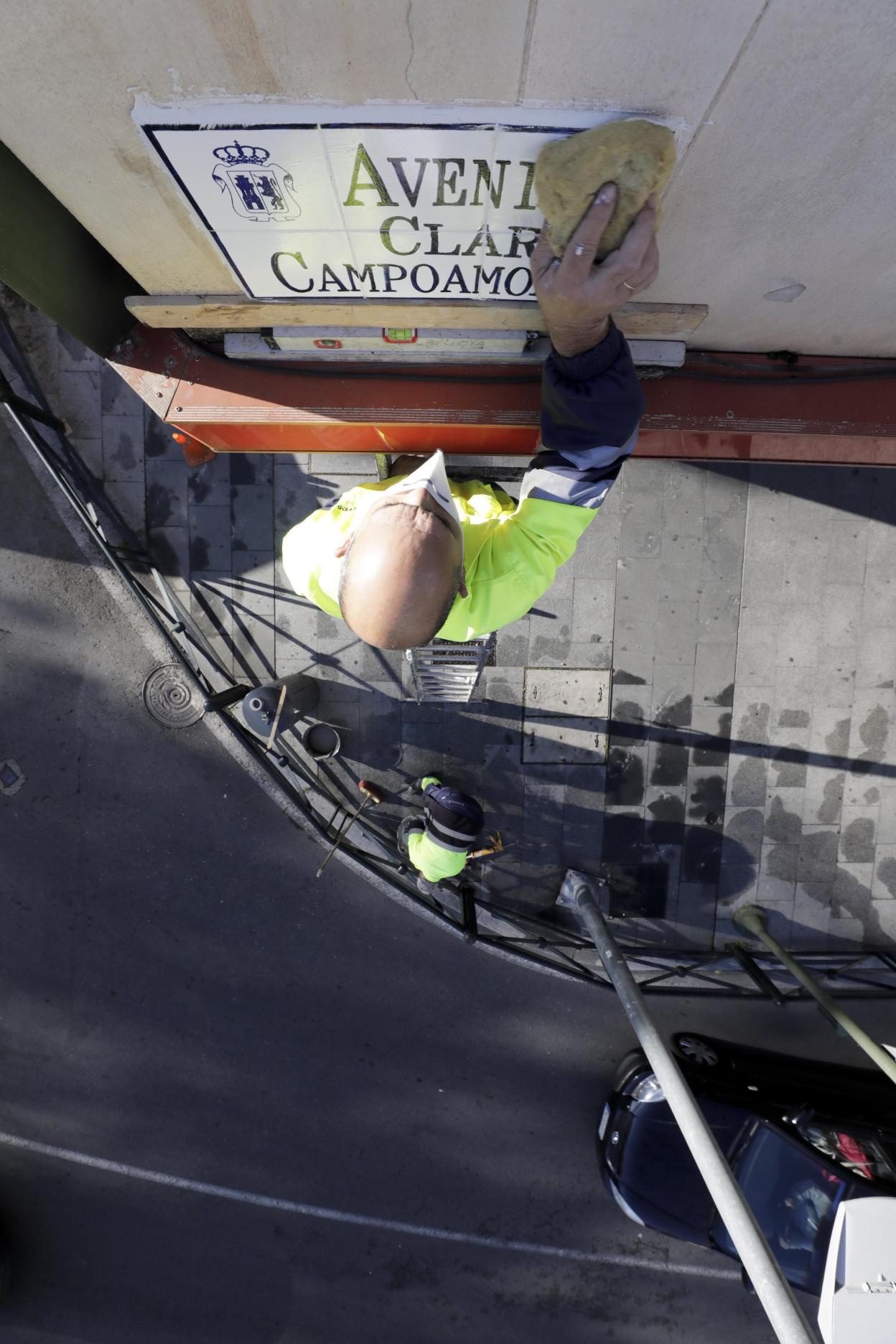 Un operario colocando ayer el azulejo de Clara Campoamor. 
