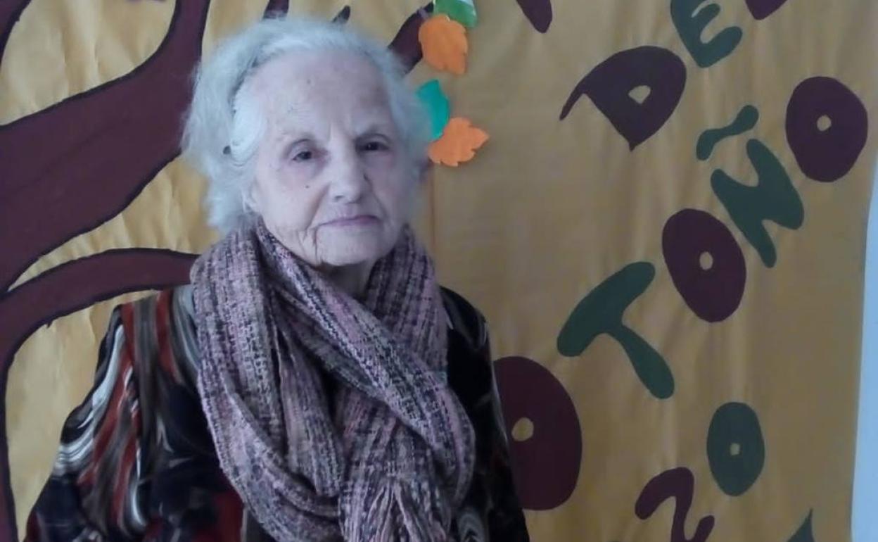 Una residente posa con el mural de la fiesta