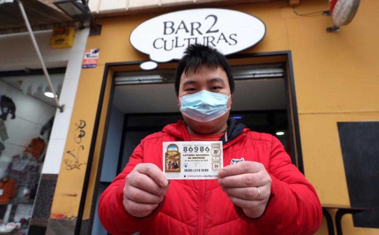 Juan, propietario del bar Dos Culturas de Zaragoza, muestra uno de los décimos agraciados.