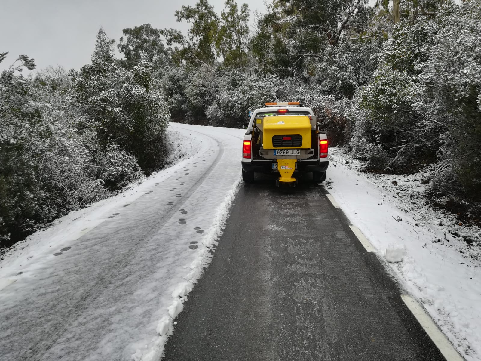Un vehículo retira la nieve en la carretera CC 20.2 Villar del Pedroso a ex 118