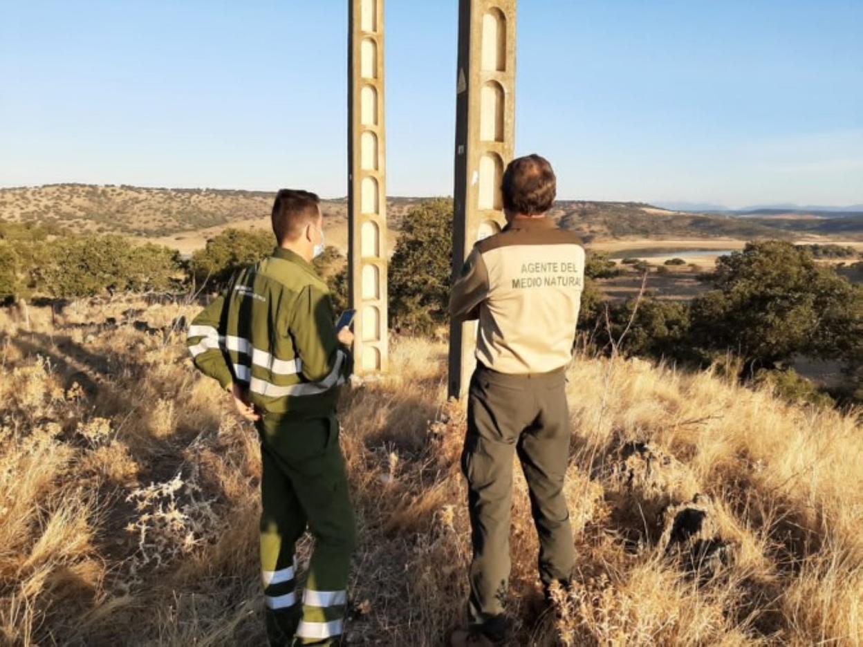 Un agente y un técnico de Iberdrola, junto a un poste eléctrico. 