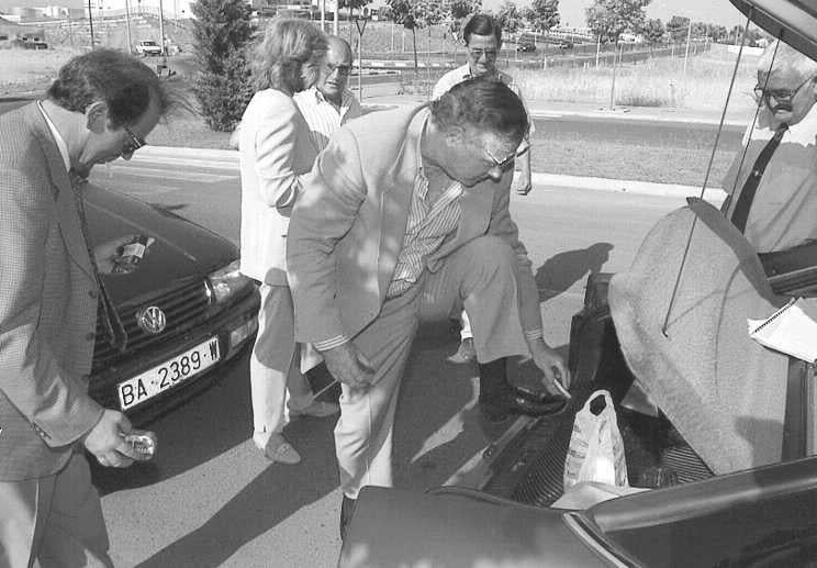 Limpiándose los zapatos en el maletero de un coche