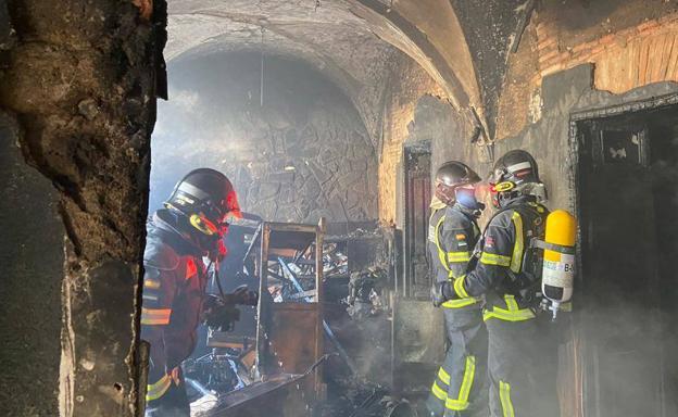 Los bomberos revisando el interior de la vivienda.