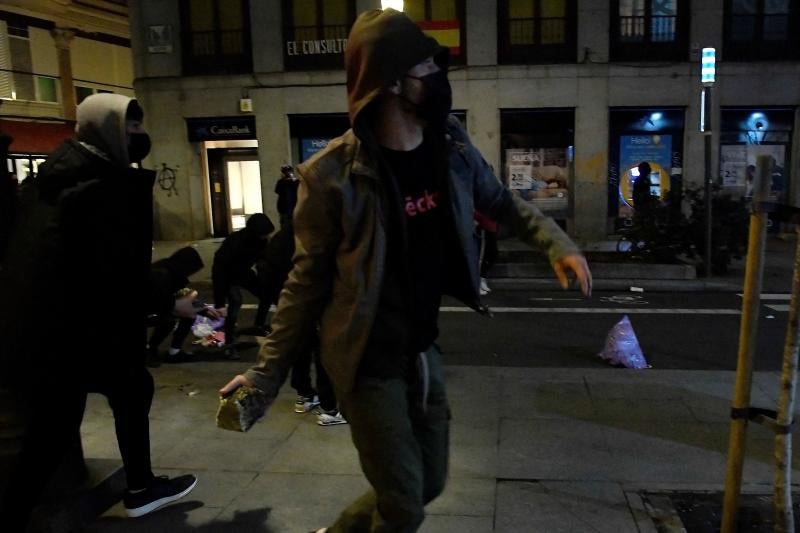 Un joven lanza piedras a la Policía en una calle de Madrid.