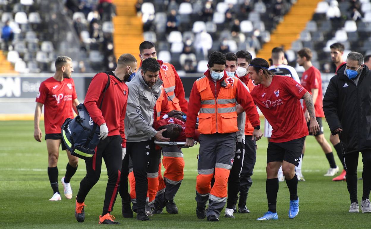 Fernando Estévez atiende al delantero del Talavera Adighibemientras es trasladado en camilla hasta la ambulancia. 