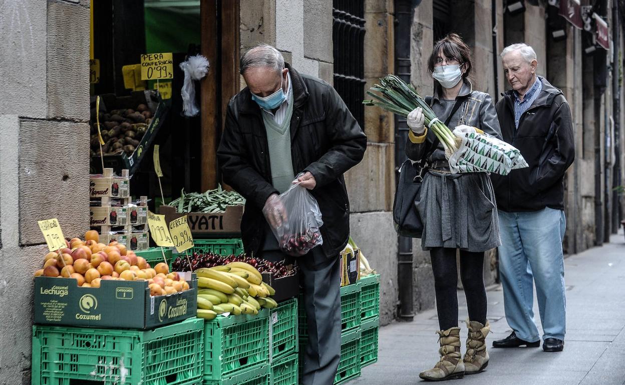 Ciudadanos comprando fruta en una tienda en Bilbao. 