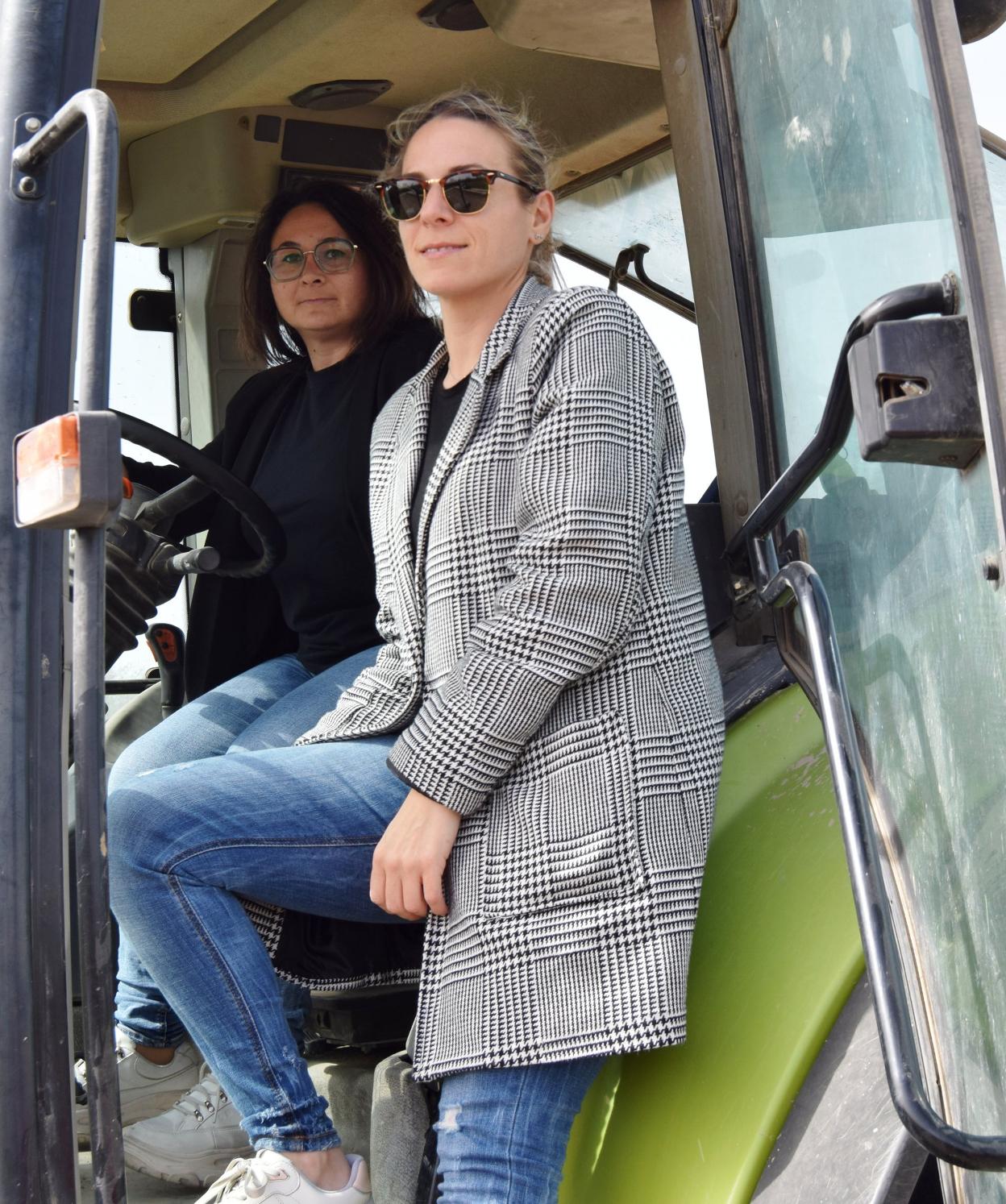 LAura y María posan en el tractor con el que trabajan. 