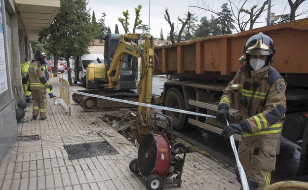 Policía y bomberos actuando ayer en el escape de gas y a la derecha la excavadora que perforó la tubería. 